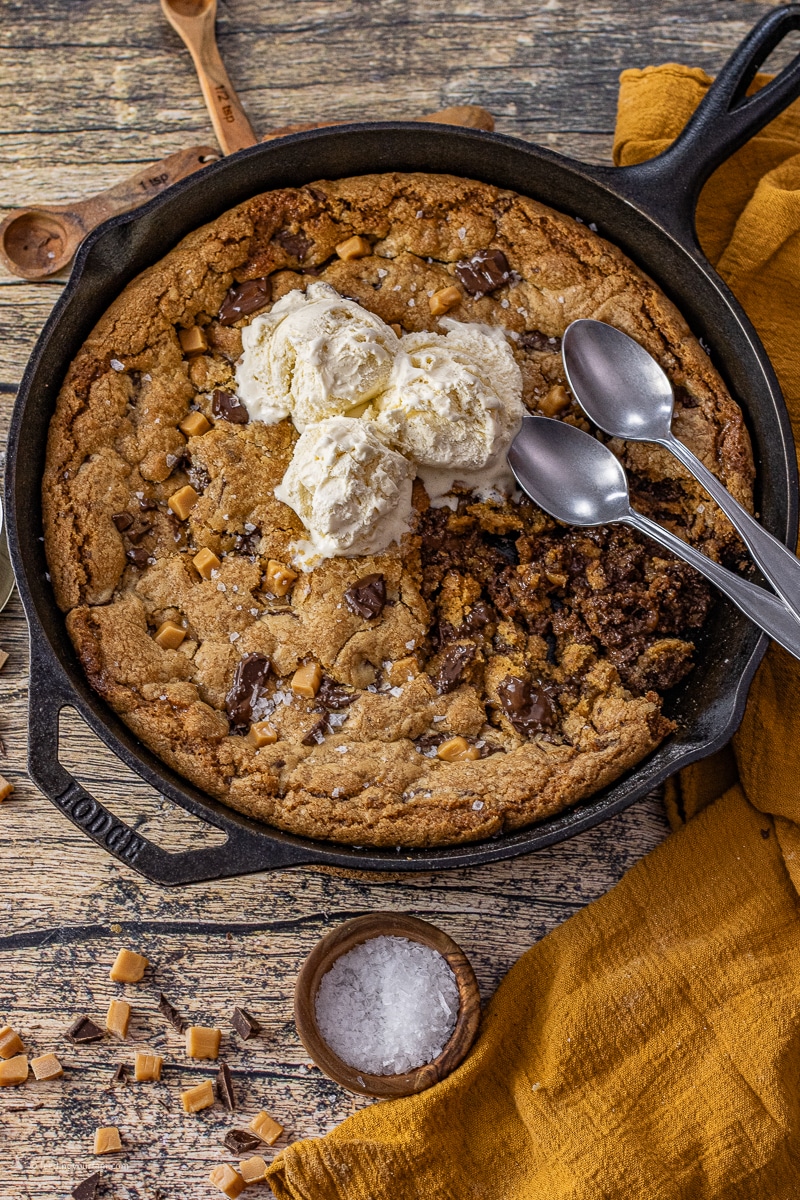 caramel chocolate chip skillet pizookie in a cast iron skillet