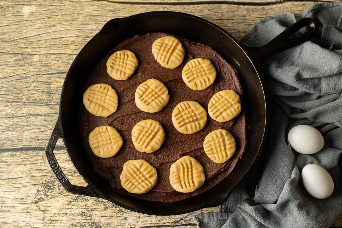 peanut butter cookies on a brownie base in a cast iron skillet