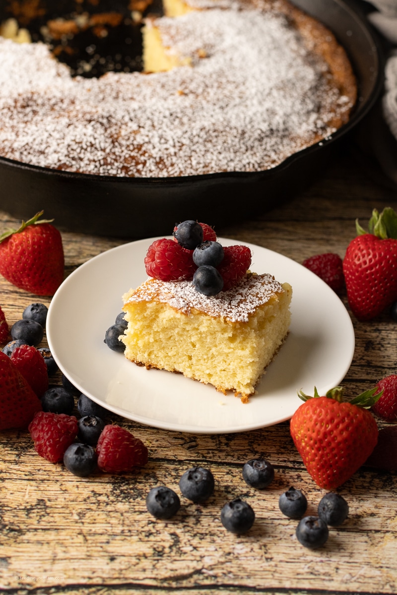 slice of butter cake on a plate topped with fresh berries