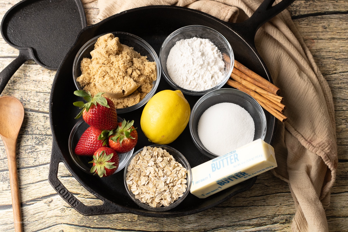 ingredients for a strawberry crisp in a skillet