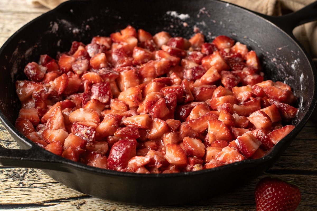 strawberries coated in flour, sugar in a cast iron pan