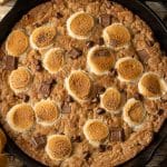 Brown Butter S’mores Skillet Cookie baked in a cast iron skillet with golden edges, melted chocolate, and toasted marshmallows on top, ready to be served warm.