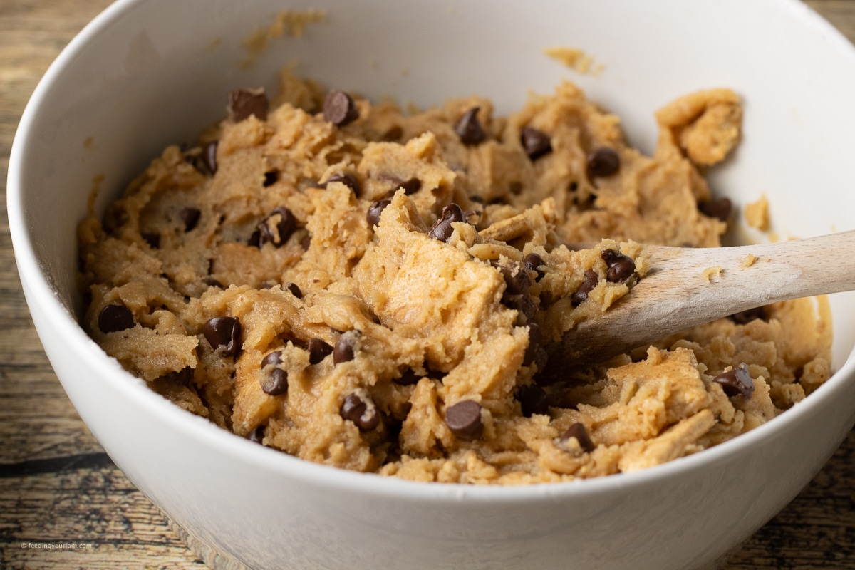 smores cookie dough with chocolate chips and graham crackers in a mixing bowl.