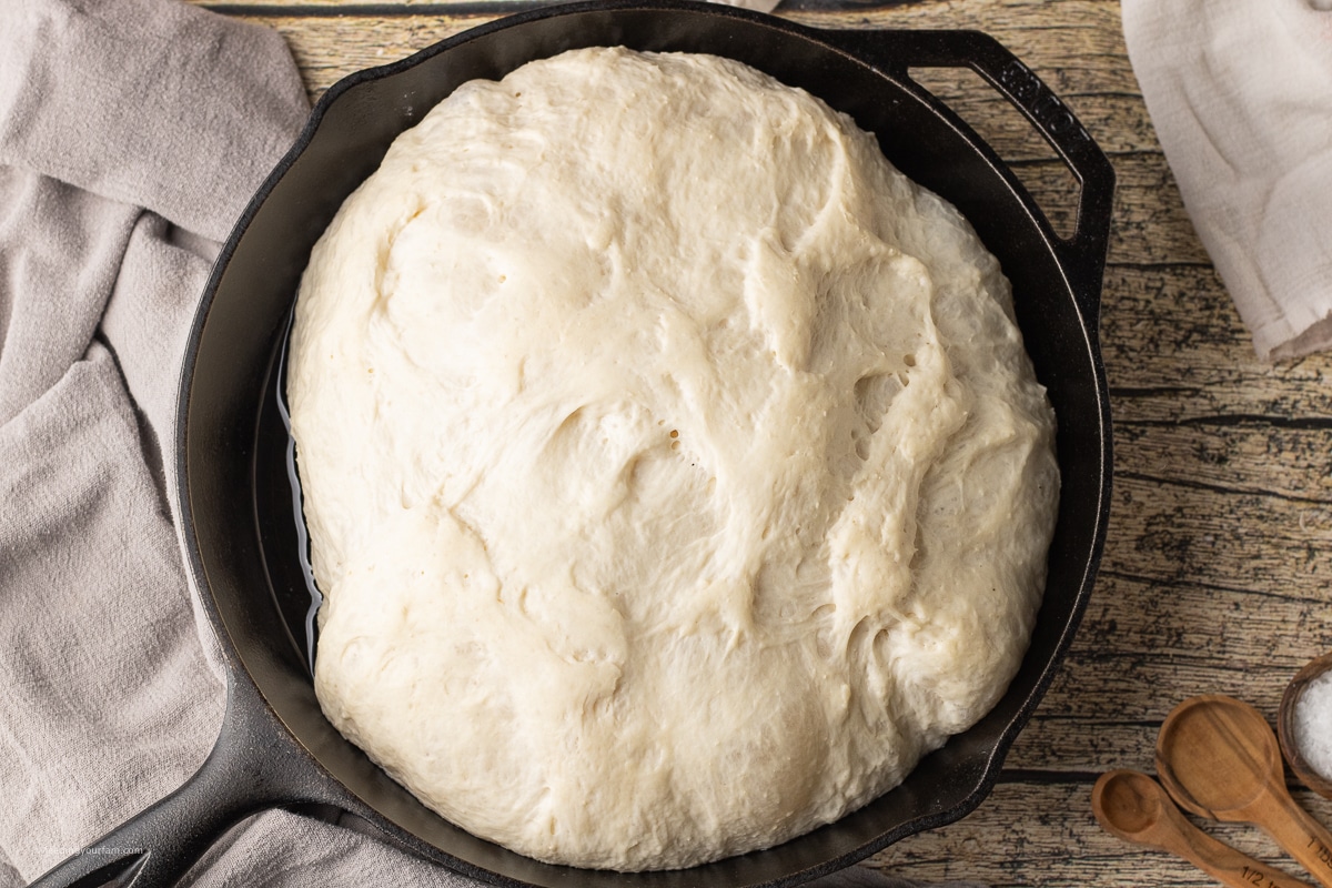 risen dough in a cast iron skillet