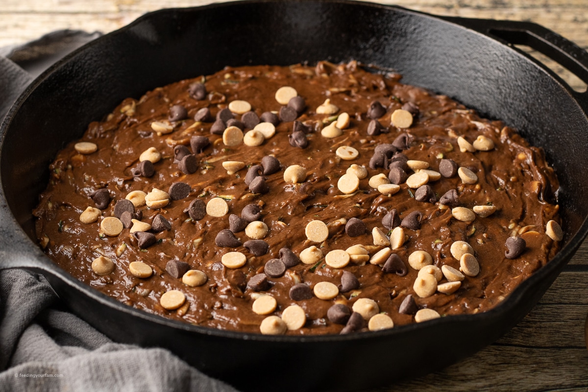 uncooked chocolate peanut butter zucchini bread spread into a cast iron skillet