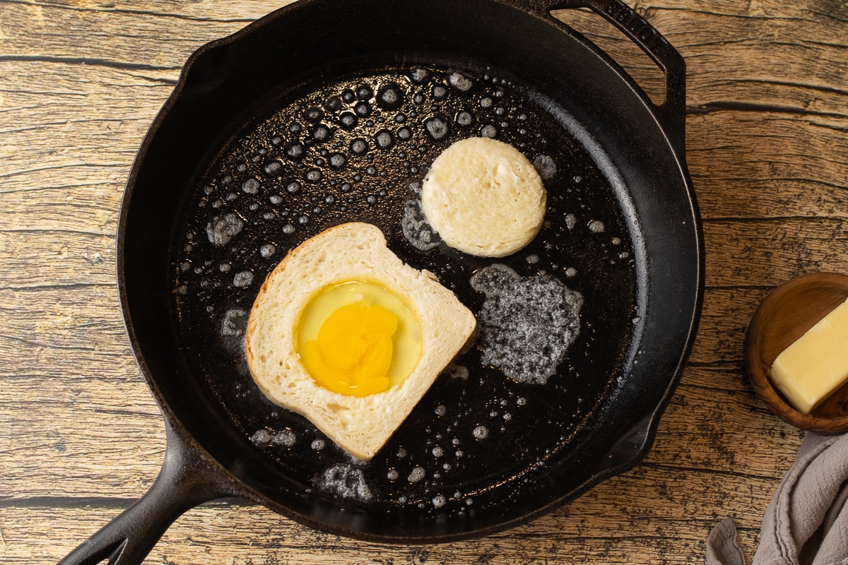 egg in a hole in a piece of white bread in a cast iron skillet