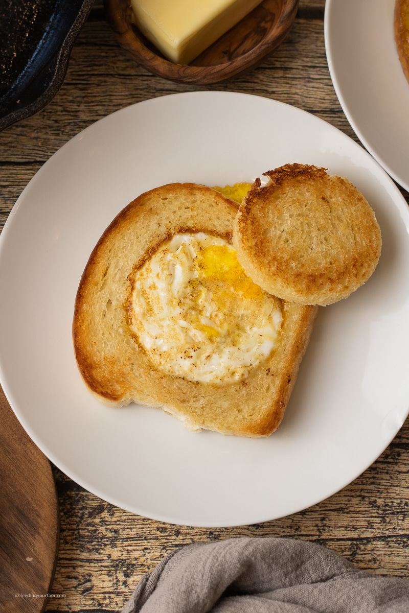 egg in a hole with white bread with a circle cut out of the middle and an egg cooked in the center.