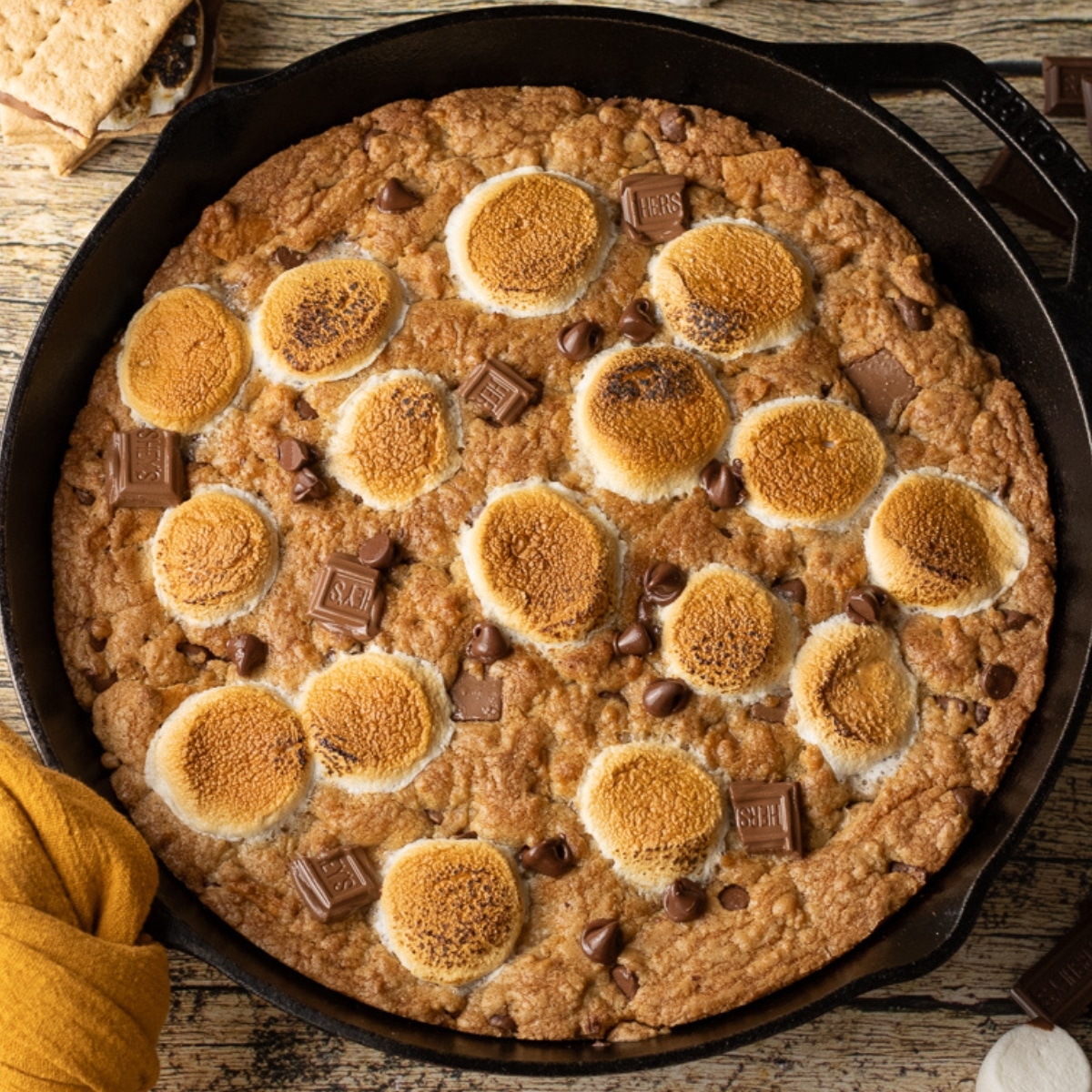 Brown Butter S’mores Skillet Cookie baked in a cast iron skillet with golden edges, melted chocolate, and toasted marshmallows on top, ready to be served warm.