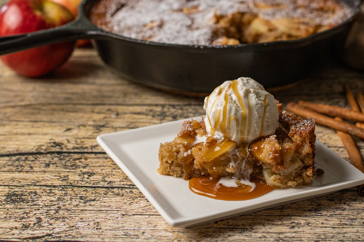 apple cake with layers of fresh apples and a sweet, cinnamon cake baked in a cast iron skillet