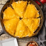 tortillas loaded with scrambled eggs and covered with cheese baked in a cast iron skillet.