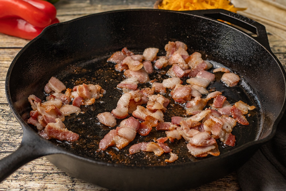 bacon cooking in a cast iron skillet