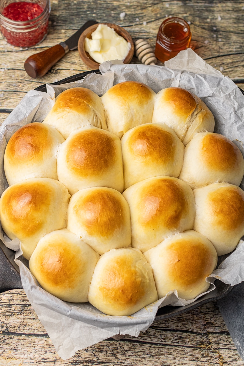 golden brown homemade dinner rolls in a cast iron skillet