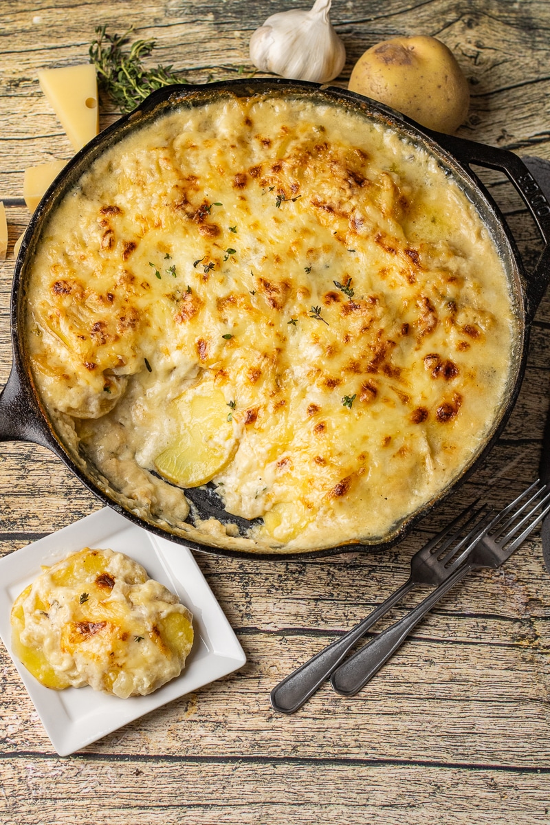 cheesy scalloped potatoes baked in a cast iron skillet