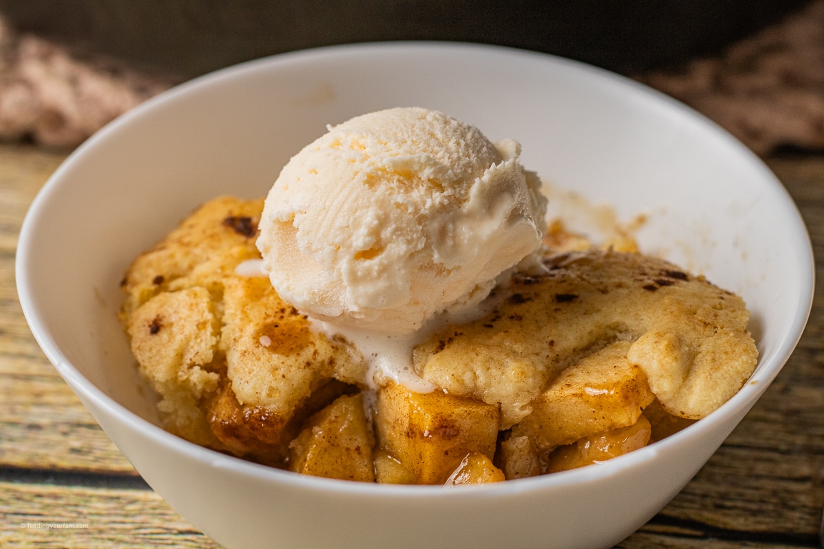 apple cobbler with caramelized apples topped with a scoop of vanilla ice cream