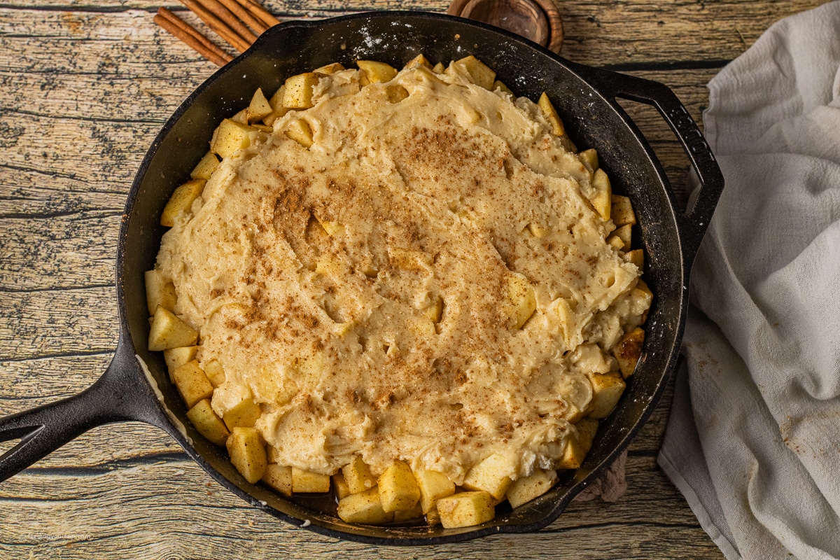 uncooked apple cobbler topped with a soft topping over chopped apples