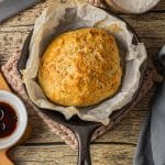 small batch of crusty bread baked in a cast iron skillet with parchment paper