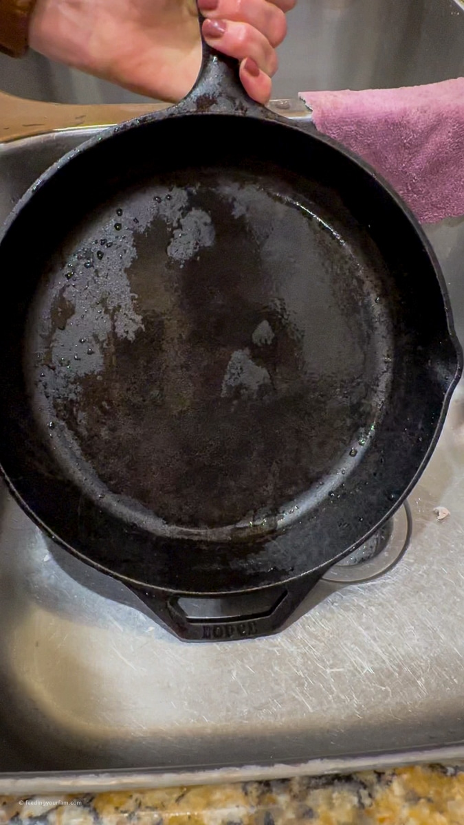 rinsing out a cast iron skillet with water