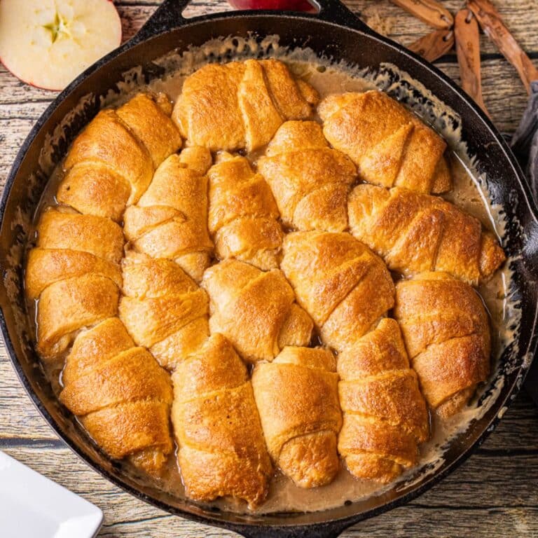 homemade caramel apple dumplings baked in a cast iron skillet with crescent roll dough