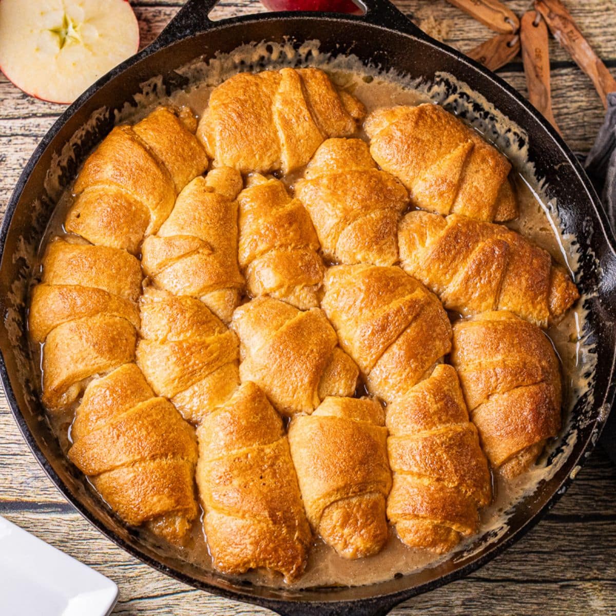 homemade caramel apple dumplings baked in a cast iron skillet with crescent roll dough