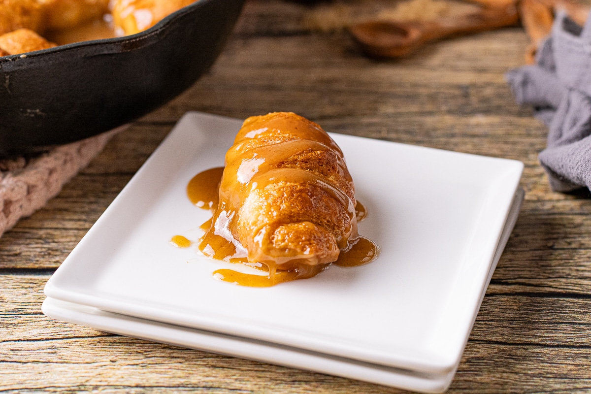 apple dumpling with caramel apple sauce baked in a cast iron skillet