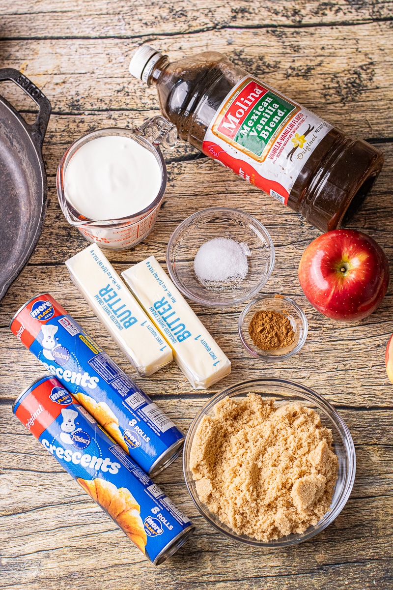 image of ingredeints for crescent roll apple dumplings including refrigerated crescent rolls, brown sugar, vanilla, salt, cinnamon, butter and apples