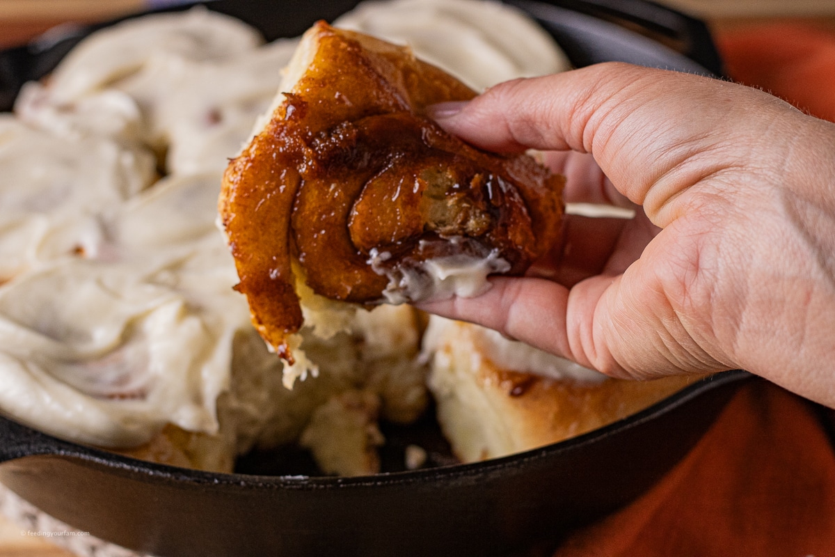 bottom of a warm cinnamon roll baked in a cast iron pan