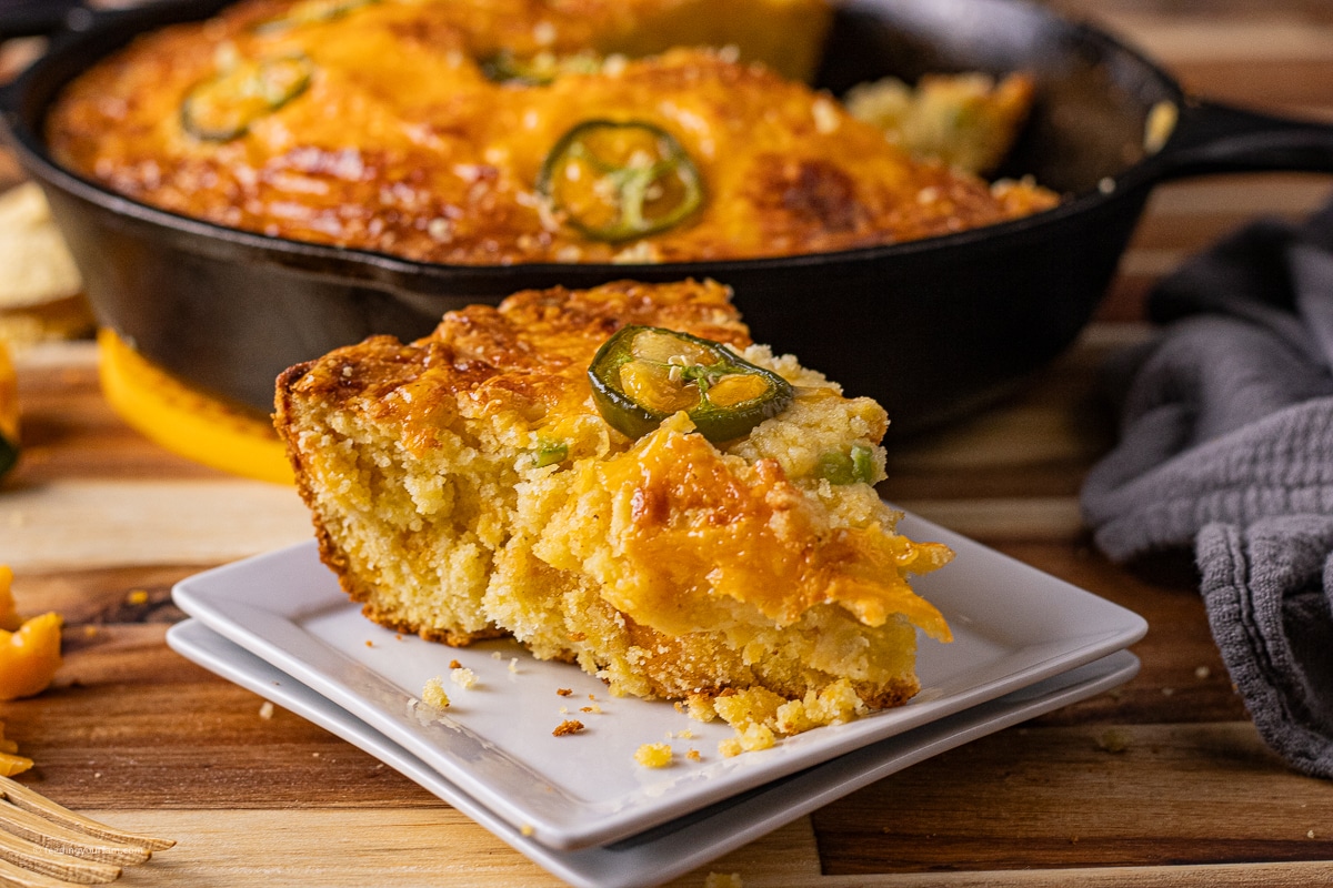 slice of cornbread with jalapeno and cheddar cheese on a white plate