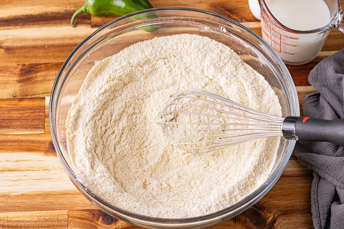 flour and cornmeal in a glass mixing bowl to make cast iron cornbread recipe with jalapenos and cornbread