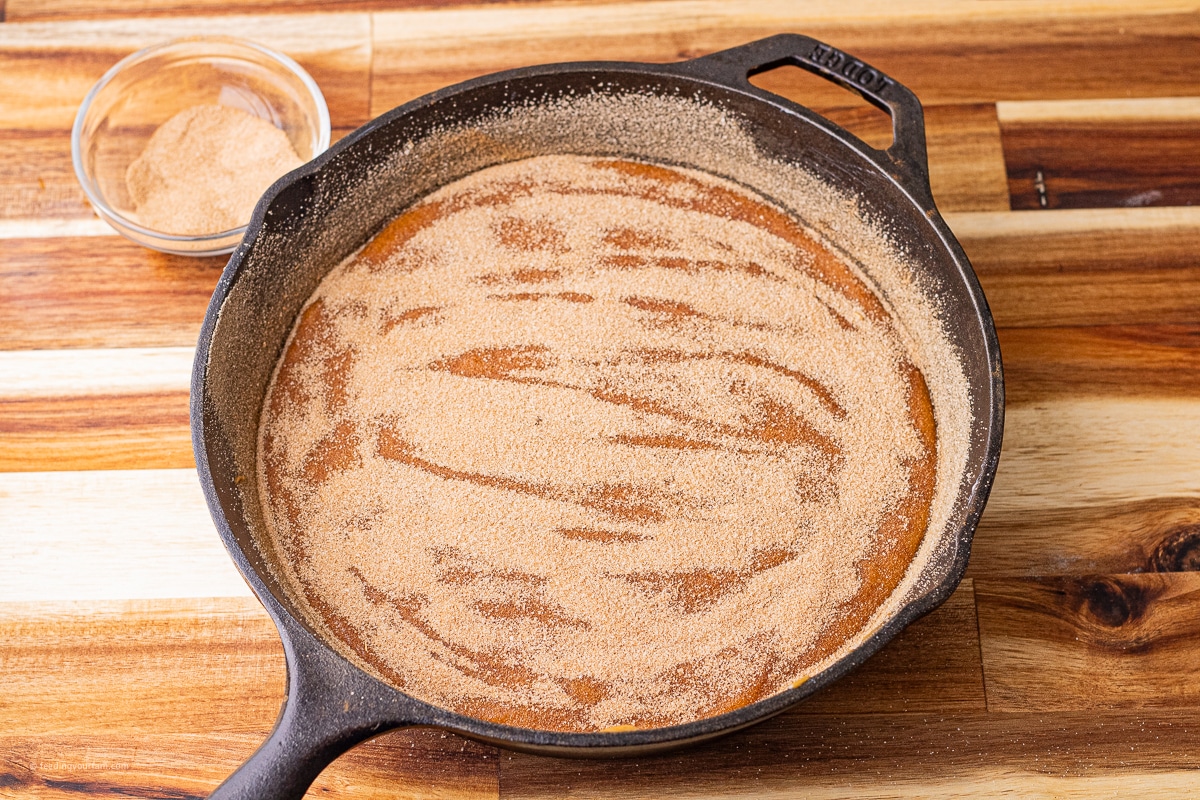 uncooked pumpkin bread with a cinnamon sugar topping in a cast iron skillet